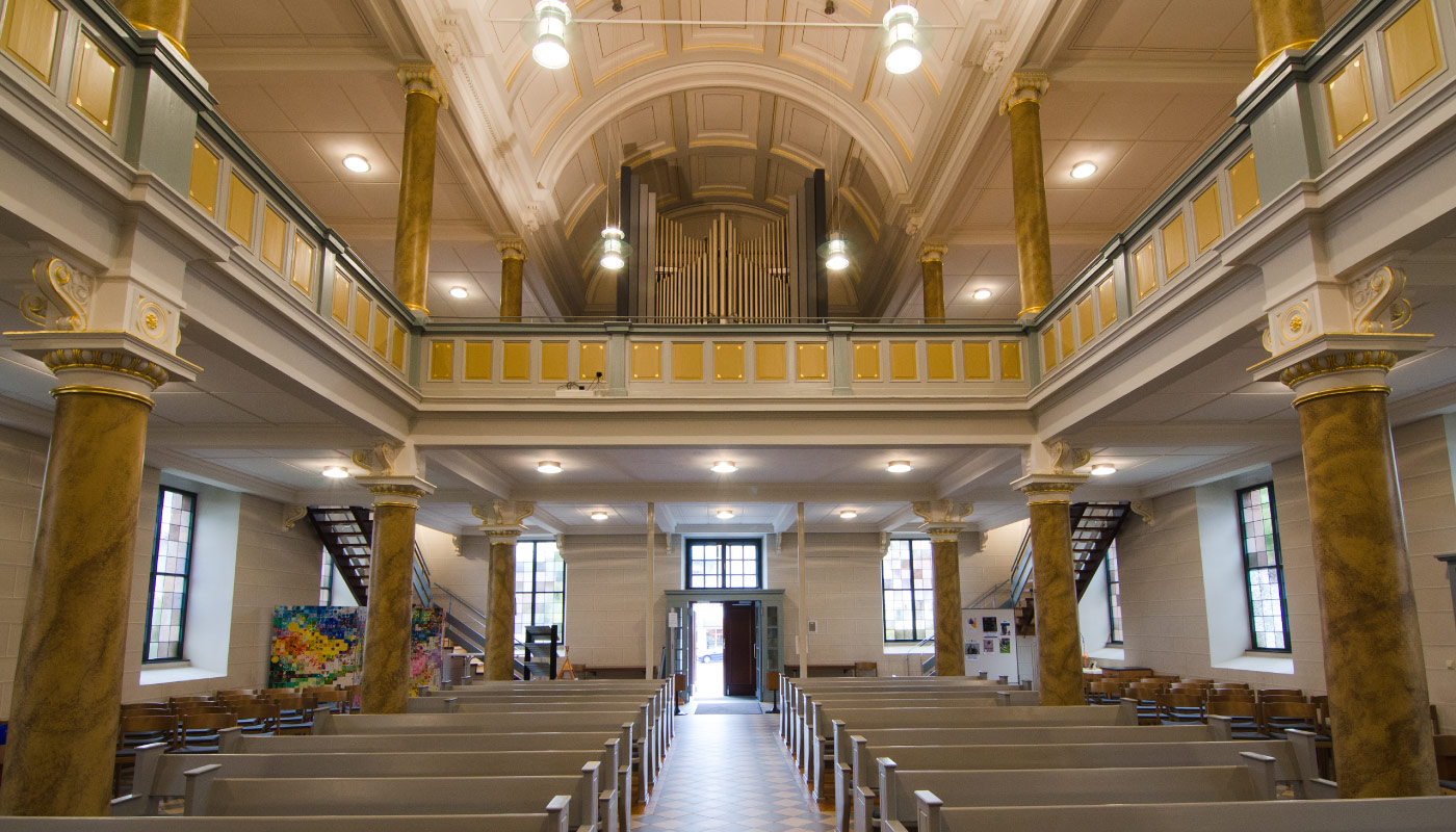 Kircheninnenraum mit Marmorsäulen, Orgel und hoher Decke