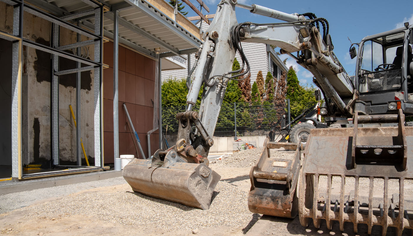 Ein Bagger mit Greifschaufel steht auf einer Baustelle in Birkenfeld